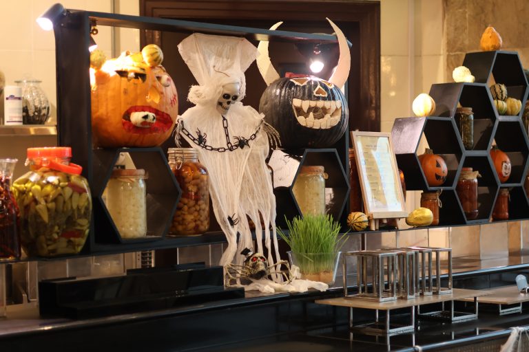 A Halloween display with carved pumpkins, a ghost figure and shelves of jars at Sevilla