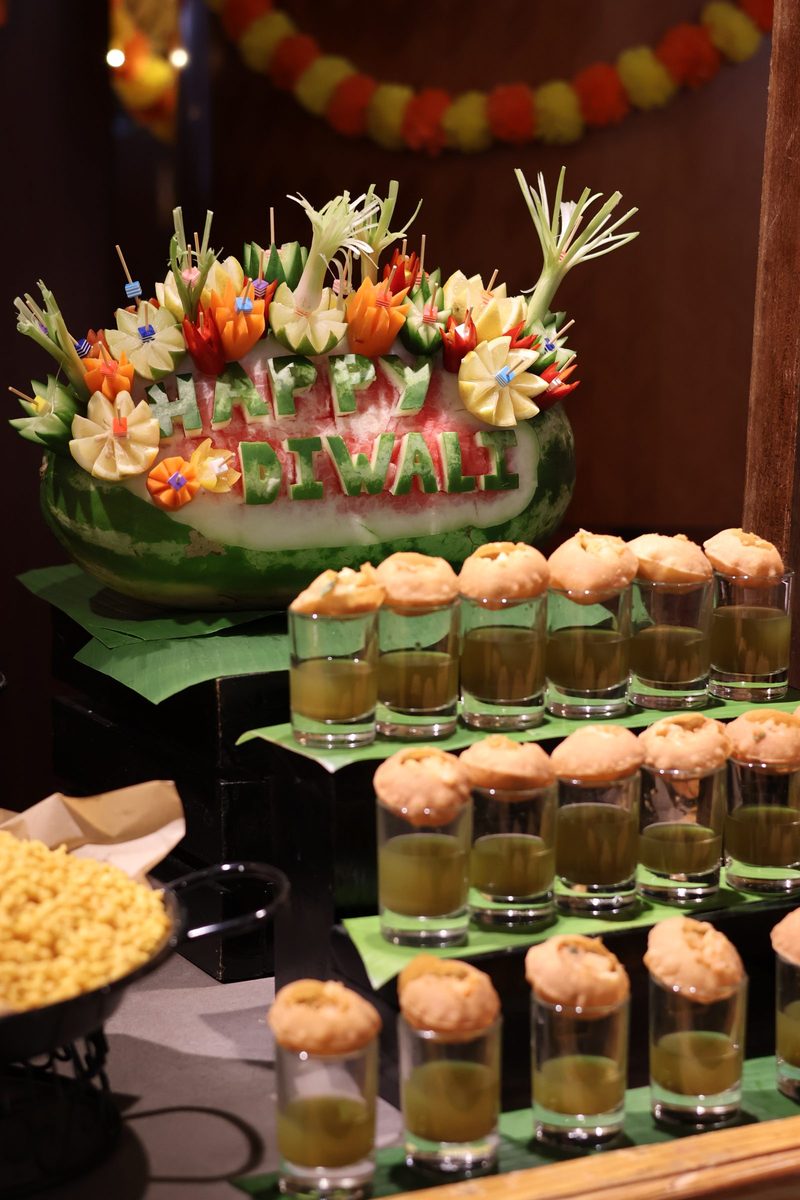 A watermelon carved with the words Happy Diwali beside Indian snacks on the Sevilla buffet