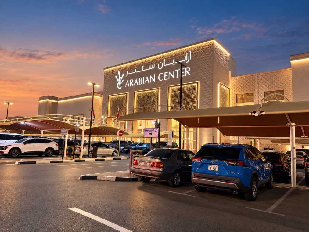 The new façade and shaded car park at Arabian Center in Al Mizhar at dusk