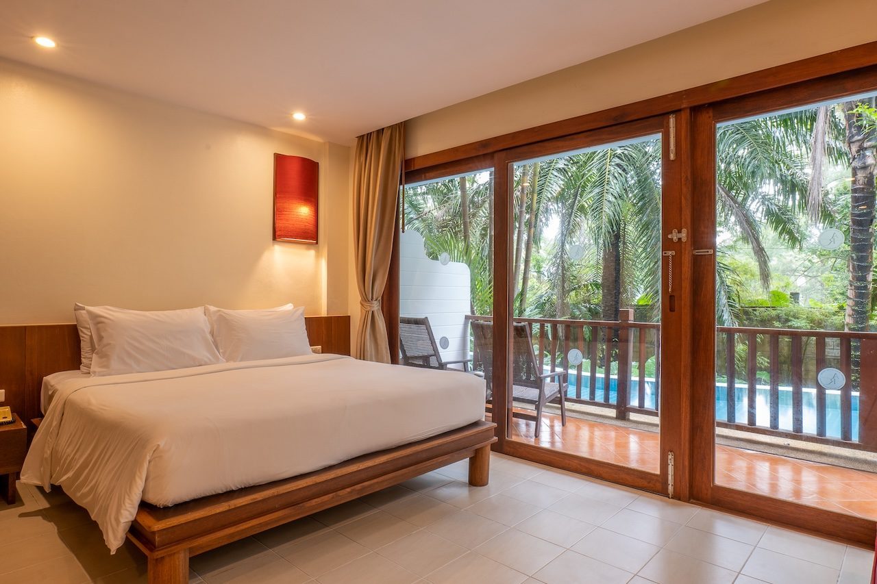 A guest room at Occidental Bangtao Beach Resort with a balcony overlooking the pool