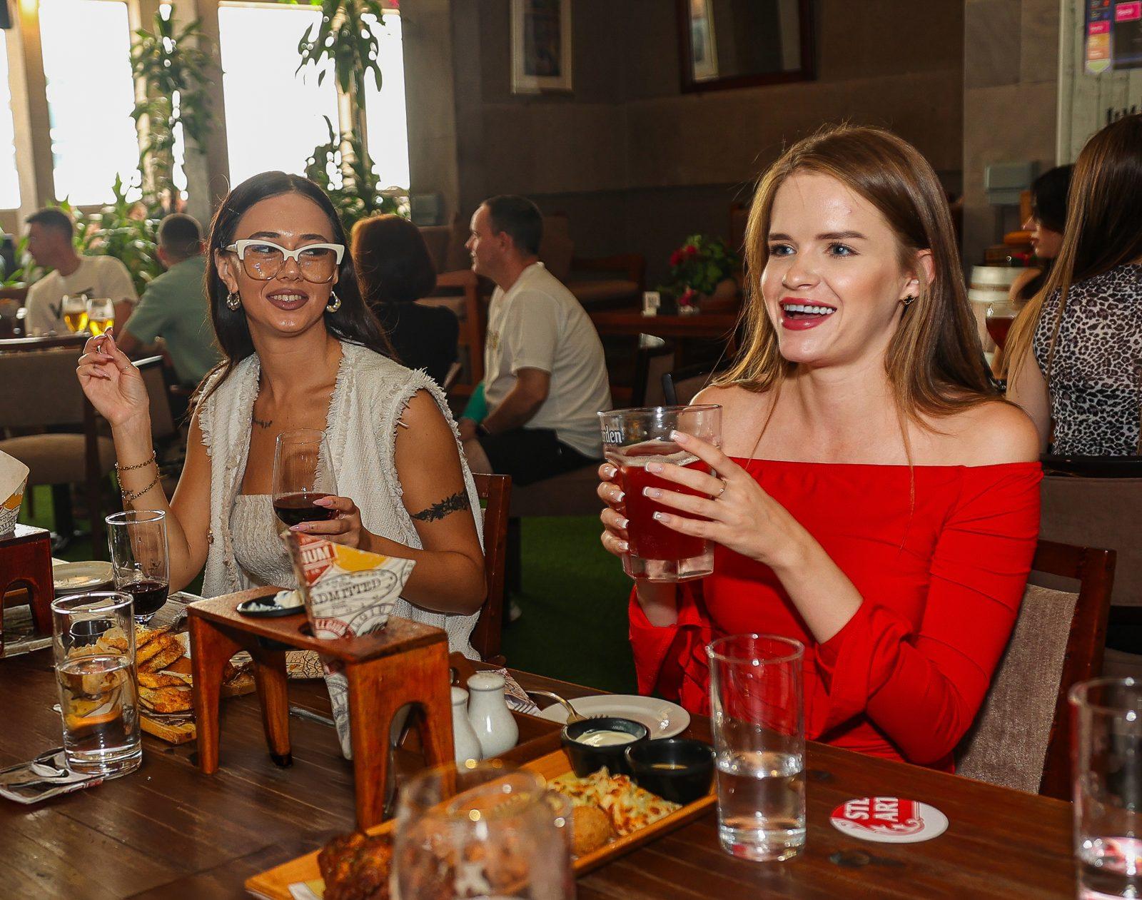 Guests with drinks and Belgian bites at a table in Belgian Beer Café, Grand Millennium Dubai
