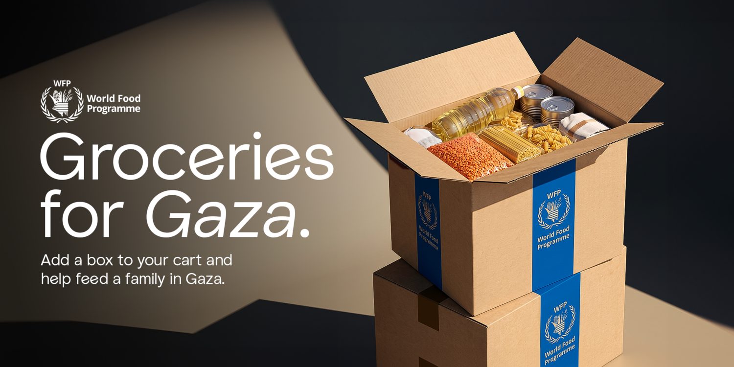 Campaign graphic for Groceries for Gaza showing an open cardboard box of staples with blue World Food Programme straps, beside the text 'Add a box to your cart and help feed a family in Gaza.'