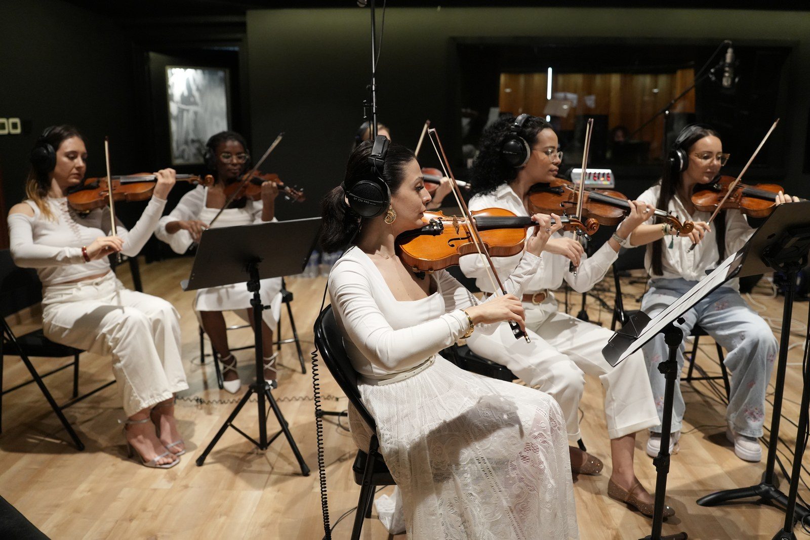 Violinists in headphones record a string session in a studio, one of the studio photos D-BELL sent with the IRIS release