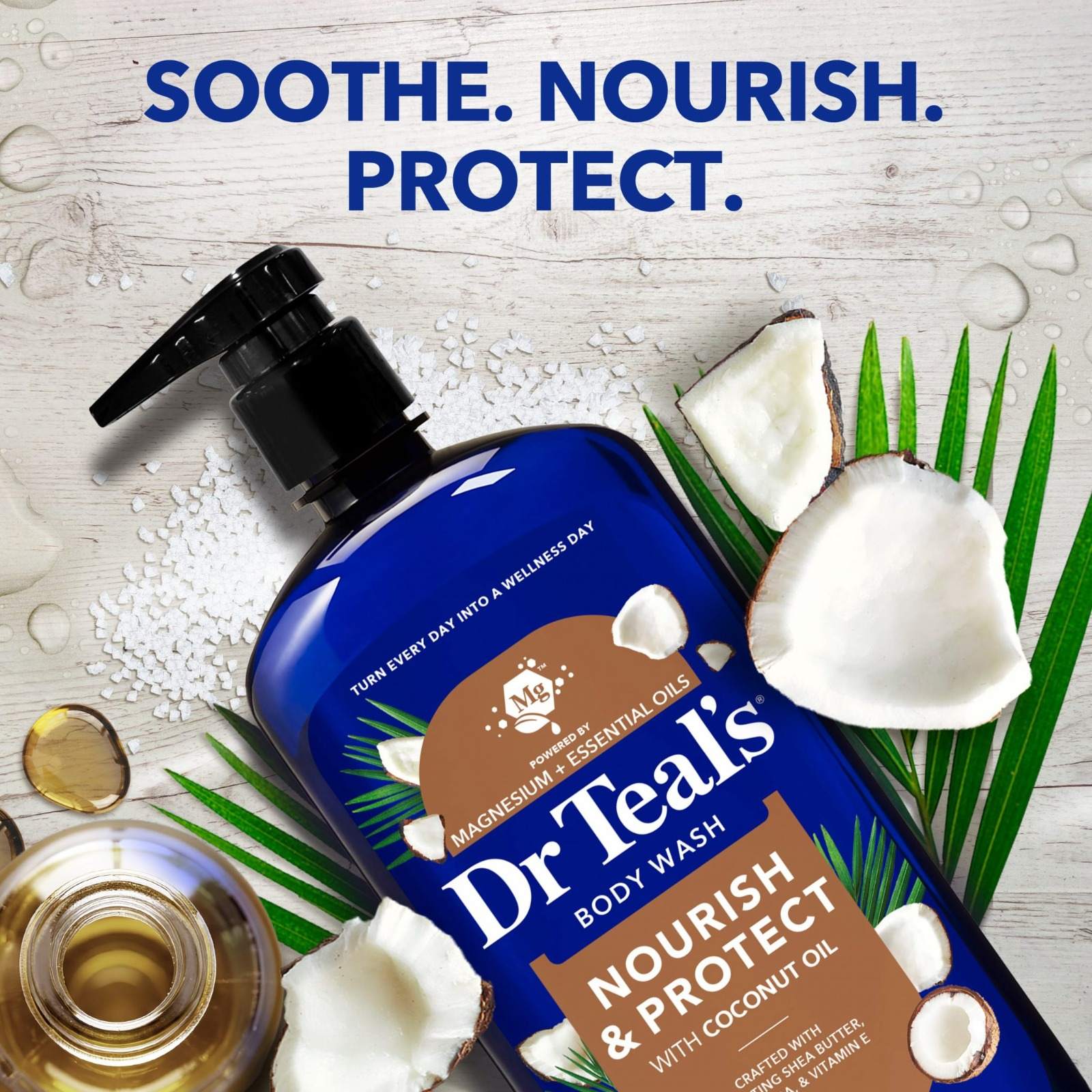 A Dr Teal’s Coconut Oil body wash bottle on a pale wooden surface with halved coconuts, palm leaves and Epsom salt crystals, with the words Soothe. Nourish. Protect.