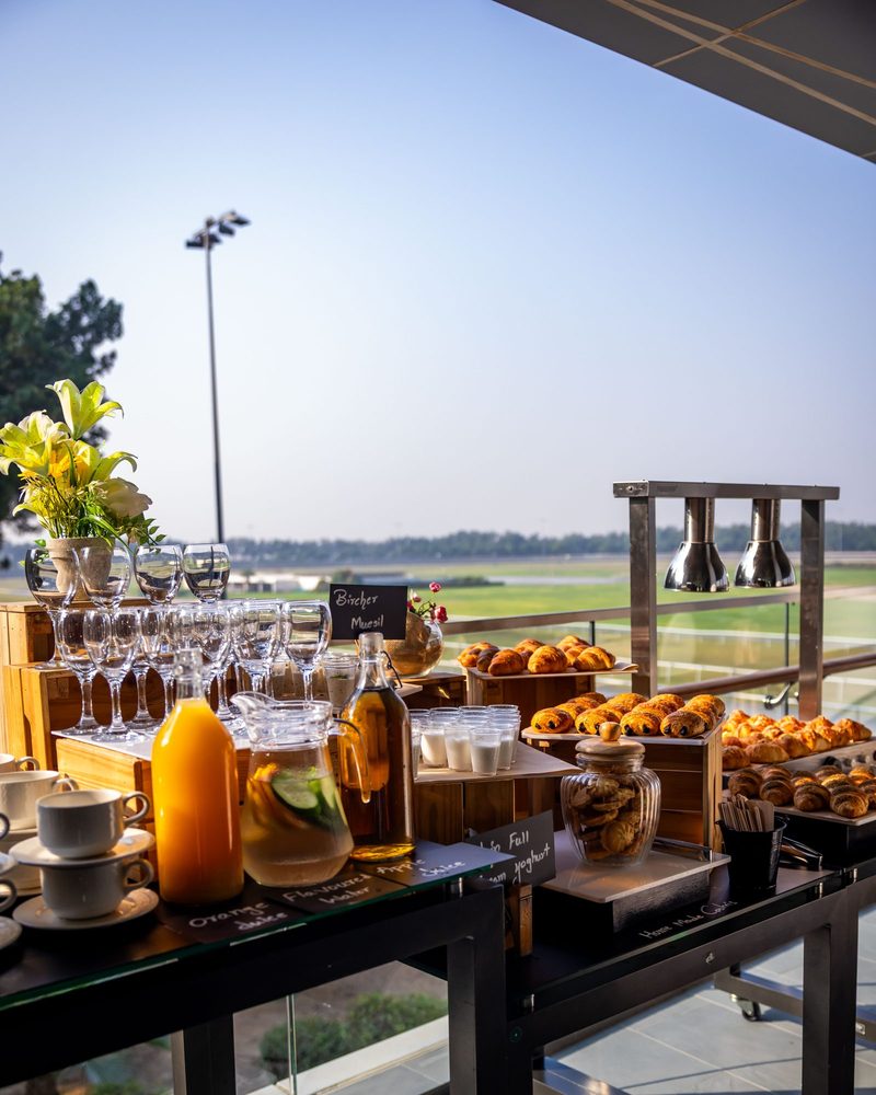 Breakfast spread on a terrace overlooking the Meydan training track