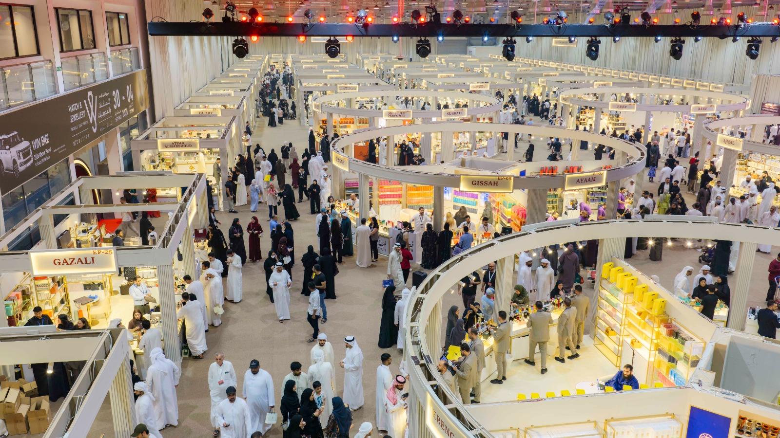 Visitors fill the aisles between rows of perfume and oud stands inside the exhibition hall at Expo Centre Sharjah