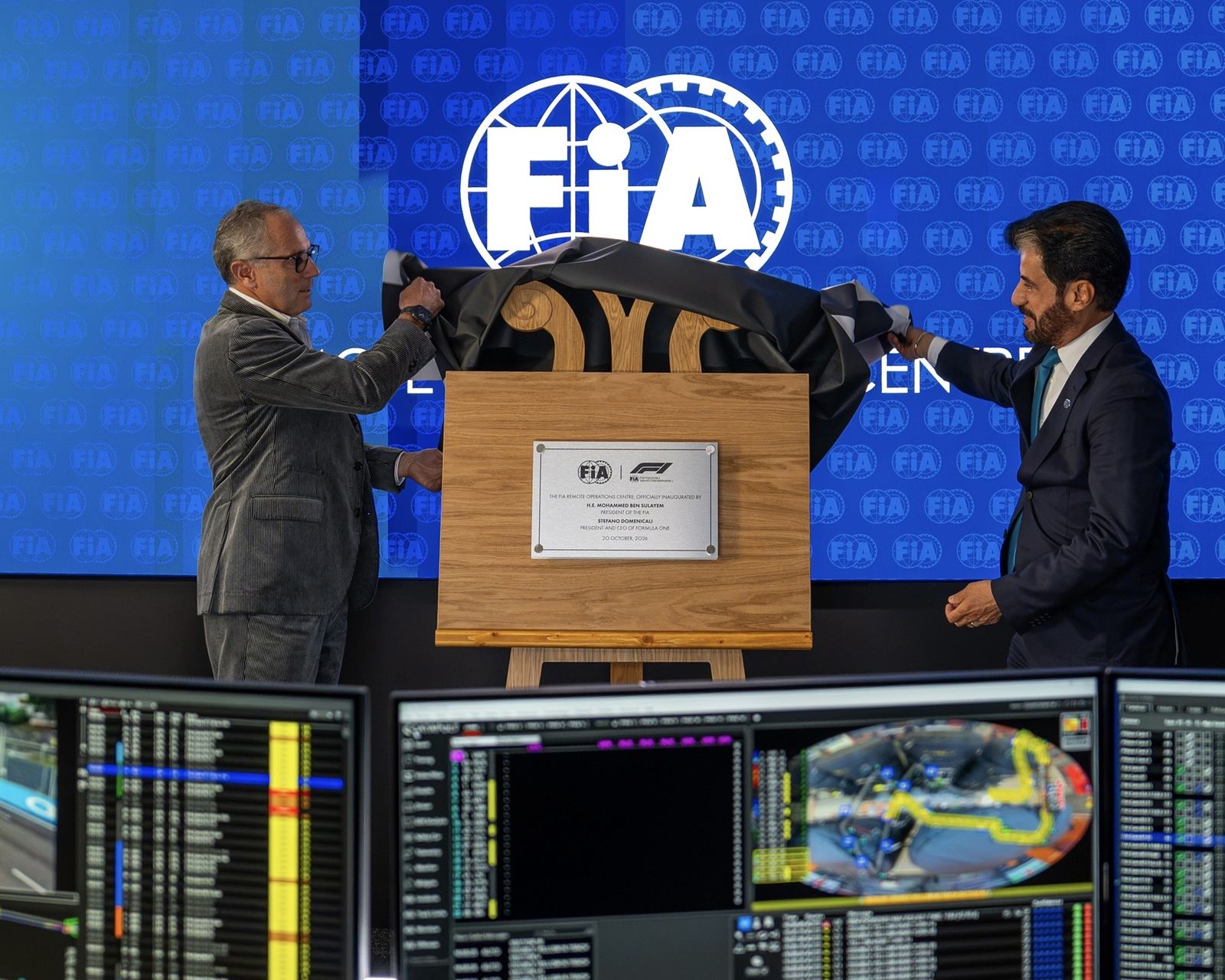 FIA President Mohammed Ben Sulayem and Stefano Domenicali unveil a plaque in front of race control screens