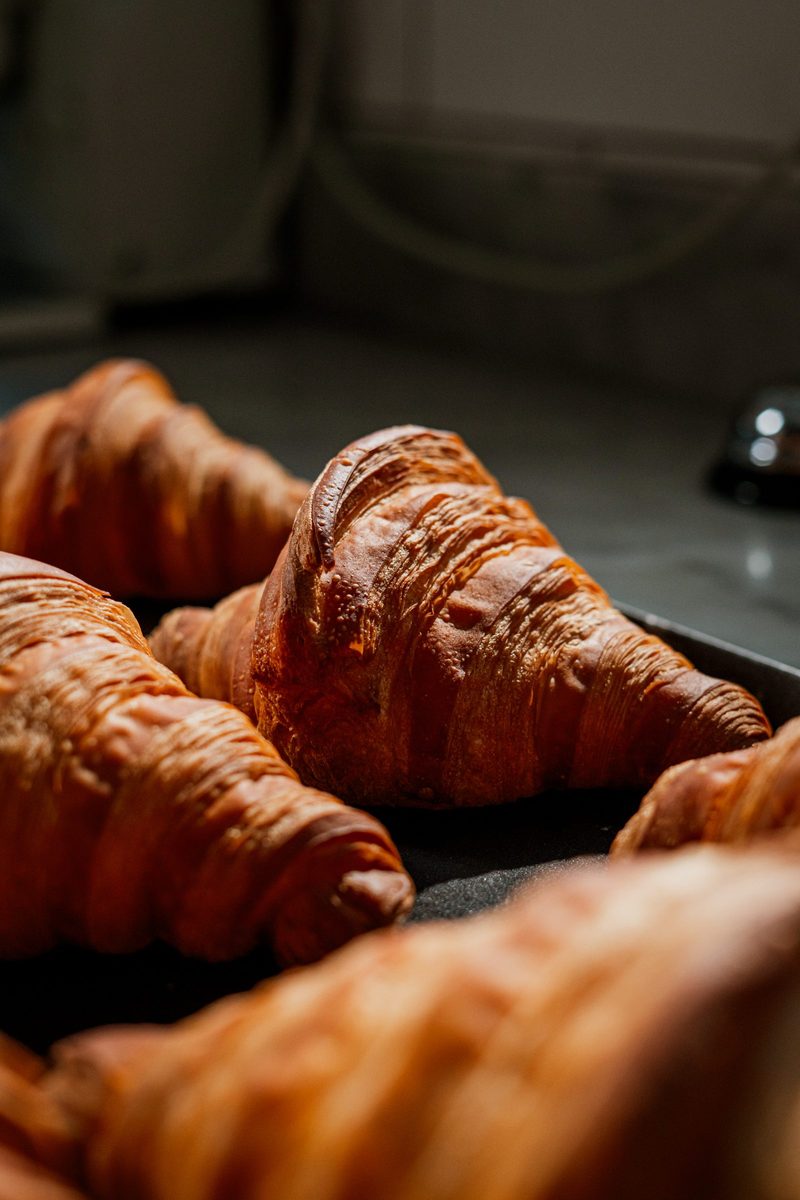 Close-up of freshly baked croissants with the serving bell behind, at The Coffee Lab
