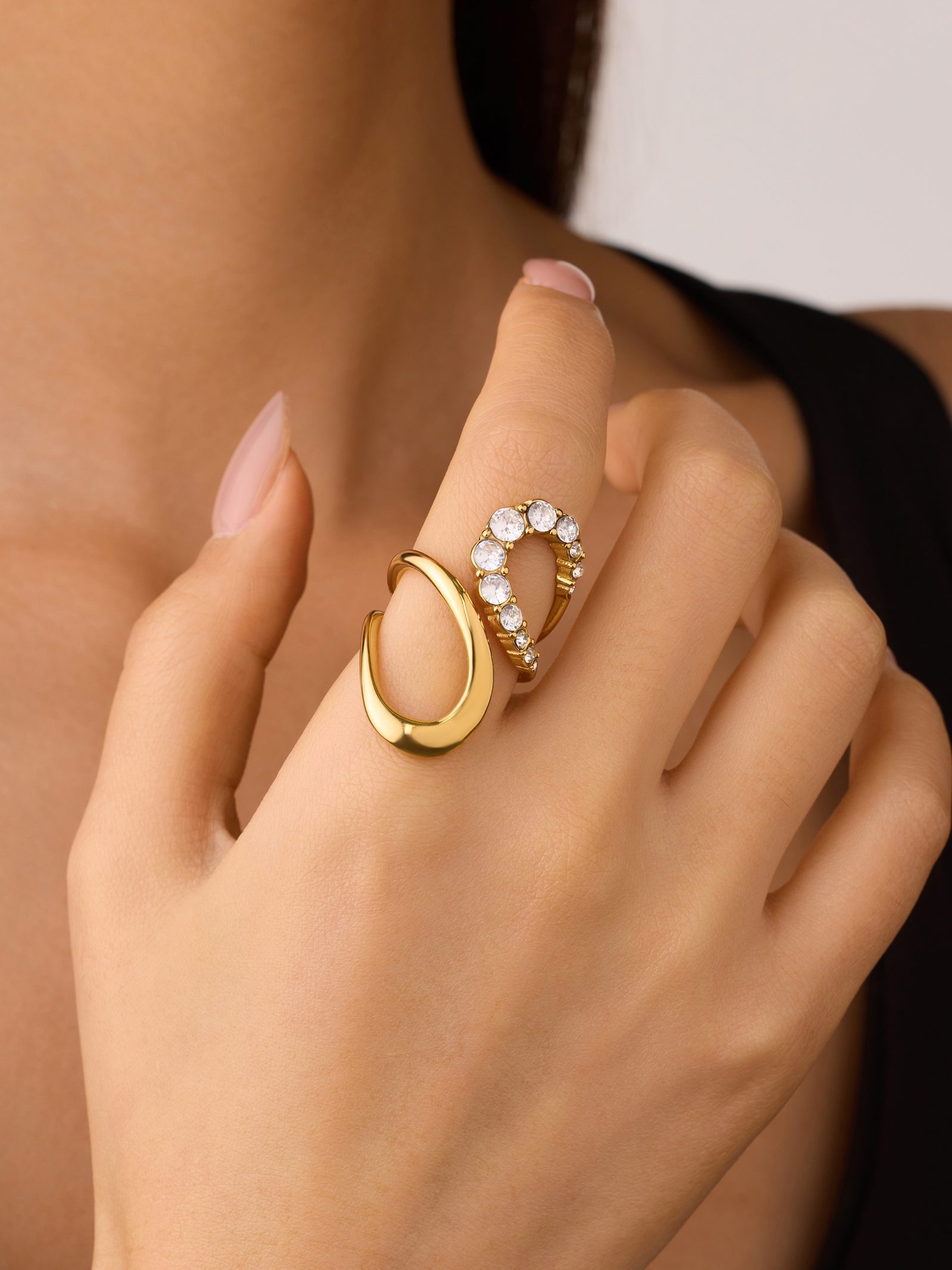 A hand wearing Miramira gold-toned rings