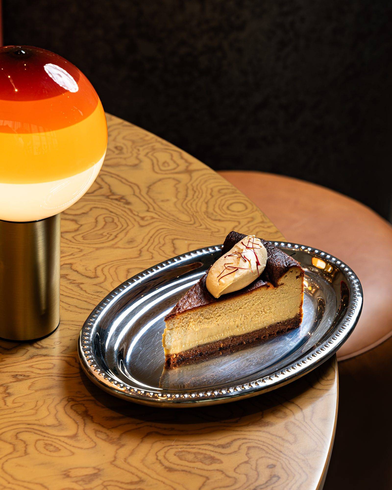 A slice of Murmur’s Karak San Sebastian cheesecake on a silver plate