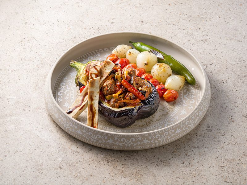 A charcoal-grilled dish with roasted peppers and onions served at Naranj Cafe