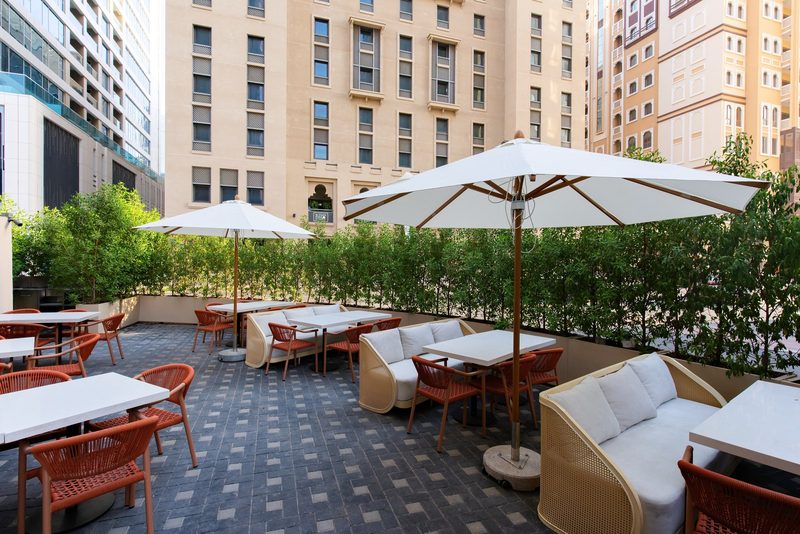 The outdoor terrace at Naranj Cafe, with parasols, sofas and dining tables