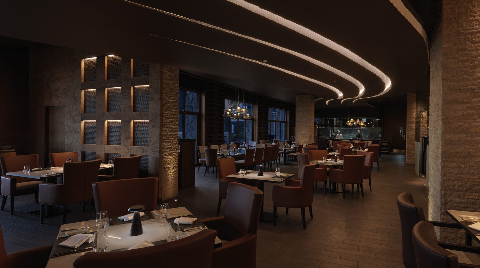 The dining room at Porterhouse Bar & Grill, Sofitel Dubai The Palm, with curved ceiling lights and tables set for dinner