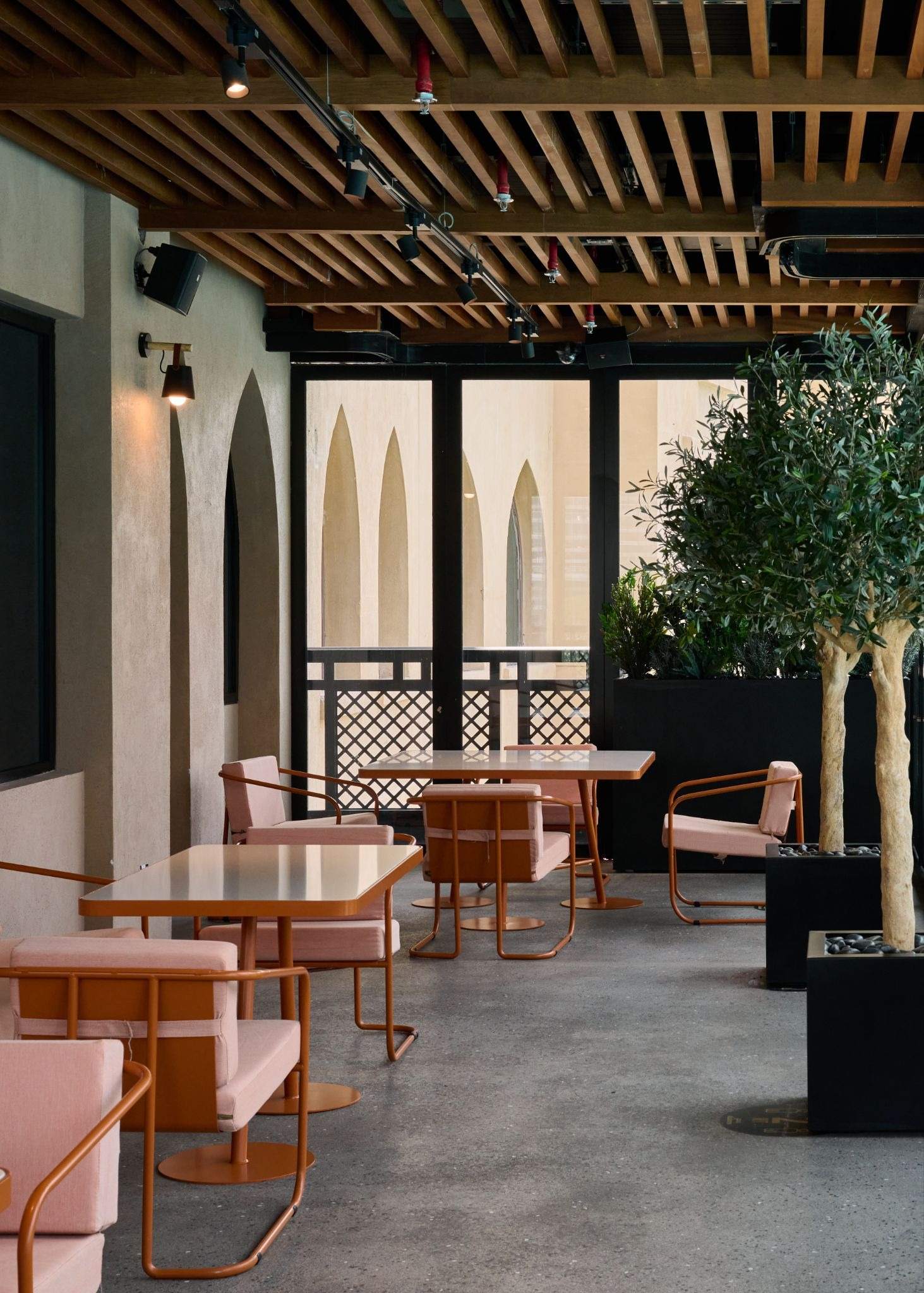 Pink chairs and tables on the covered terrace at Time Out Market Dubai in Souk Al Bahar