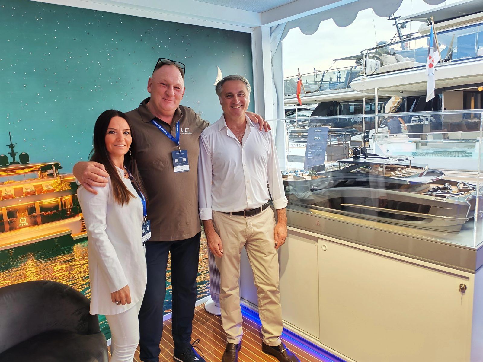 Erica Broilo, Olaf Steckstor and Antonio Luxardo at a boat show stand beside a yacht model